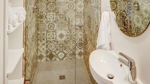 Une salle de bain avec une douche, un lavabo et un miroir.