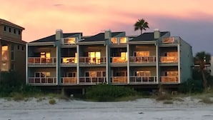Een hotel met meerdere verdiepingen en balkons, gelegen nabij een strand.
