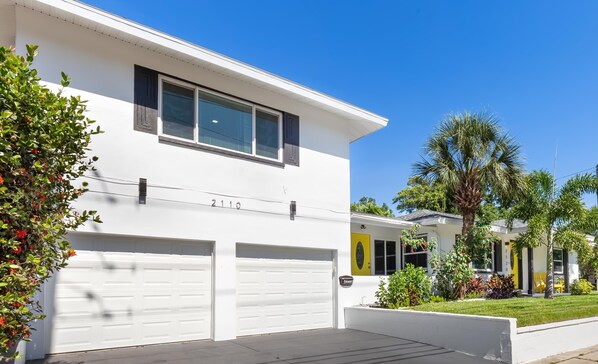 A modern two-story house with a white exterior, two garage doors, and a number '2110' displayed above the garage. - Experience the Vibrant Downtown St Pete! (St. Petersburg)