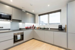 Apartamento básico, várias camas | Cozinha privada | Geladeira, micro-ondas, fogão, cooktop