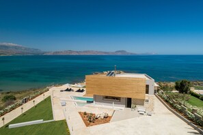 A modern house with a pool, a garden, and a view of the ocean. - Your Private Retreat by the beach, with Heated Pool (Petres, Rethymno)