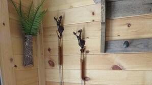En vägg av trä med två metallföremål formade som hjorthorn och en liten krukväxt.