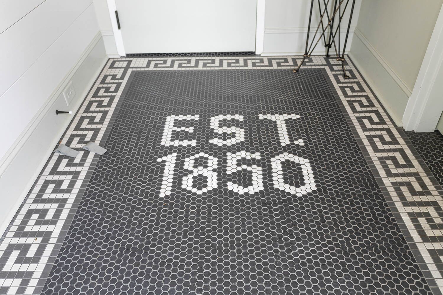 Een zeshoekig patroon in de vloer, met 'EST. 1850' in het midden.