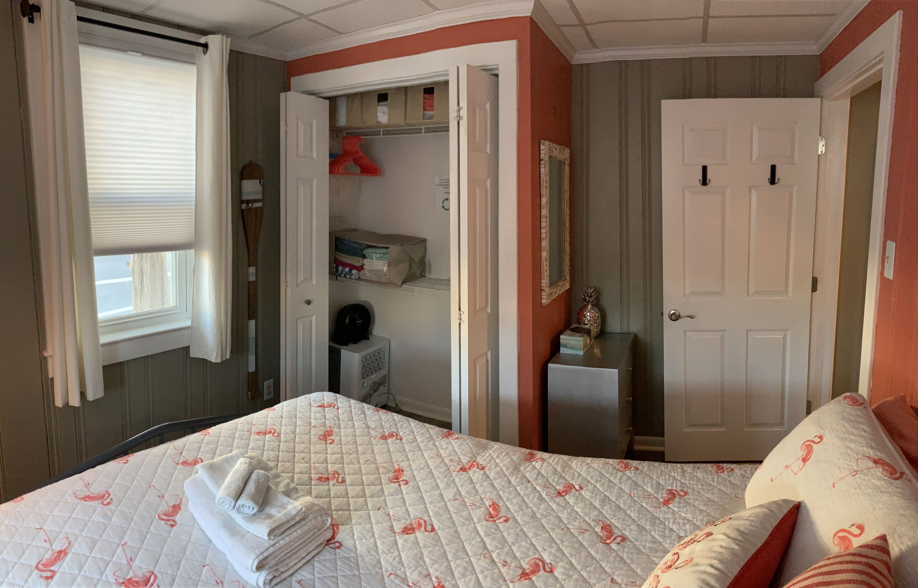 A bedroom with a bed, a bedside table, a wardrobe, and a door.