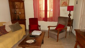 A living room with a sofa, armchair, and a wooden coffee table. - Maison de Vacances Gard/cevennes (Cardet)