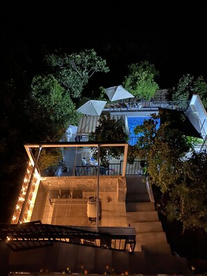 Eine Dachterrasse mit Essbereich, Pool und einer Treppe, die in die obere Etage führt.