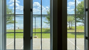 A view through a large window with a clear sky and a body of water. - Island View Hotel Bar Harbor (Trenton)