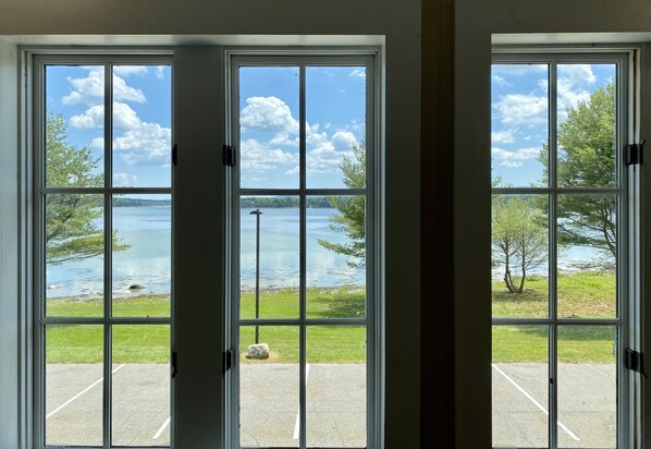 A view through a large window with a clear sky and a body of water.