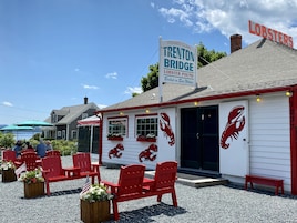 Un restaurante frente al agua con sillas rojas y decoración con motivos de langosta.
