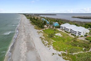 A coastal hotel with a beach view, multiple-story buildings, and a landscaped area with pathways. - Sublime Gulf Beach Villas Residence on Captiva (Captiva)