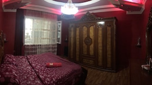 Een slaapkamer met een bed, een garderobe en een kroonluchter.