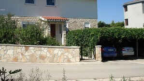 A two-story house with a stone facade, a tiled roof, and a gated driveway. - Apartment in Drage with Terrace, Air condition, WIFI (5013-2) (Drage)