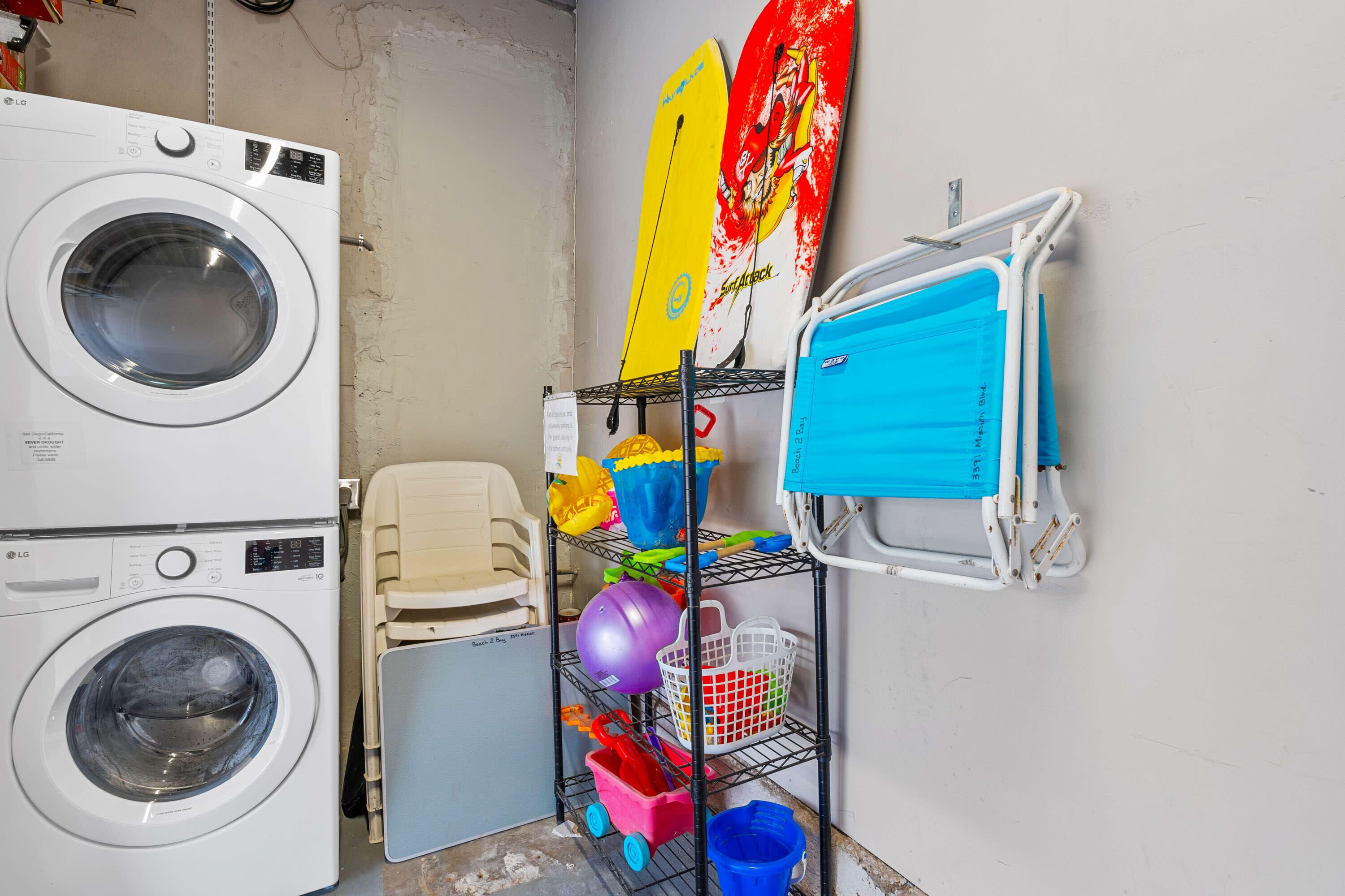 A laundry room with two washing machines, a drying rack, and various cleaning supplies.
