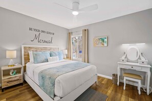 A bedroom with a bed, nightstand, dresser, and a wall with a mermaid quote. - Beach-2-Bay 2br | Beach | AC | Patio (San Diego)