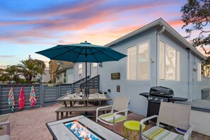 A patio with a table, chairs, a grill, and a view of a house. - Beach-2-Bay 2br | Beach | AC | Patio (San Diego)