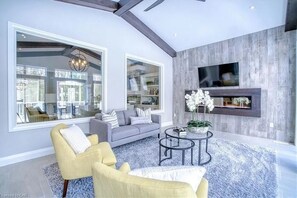 Relax in this stylish living room with a large window, grey sofa, and flat-screen TV.
