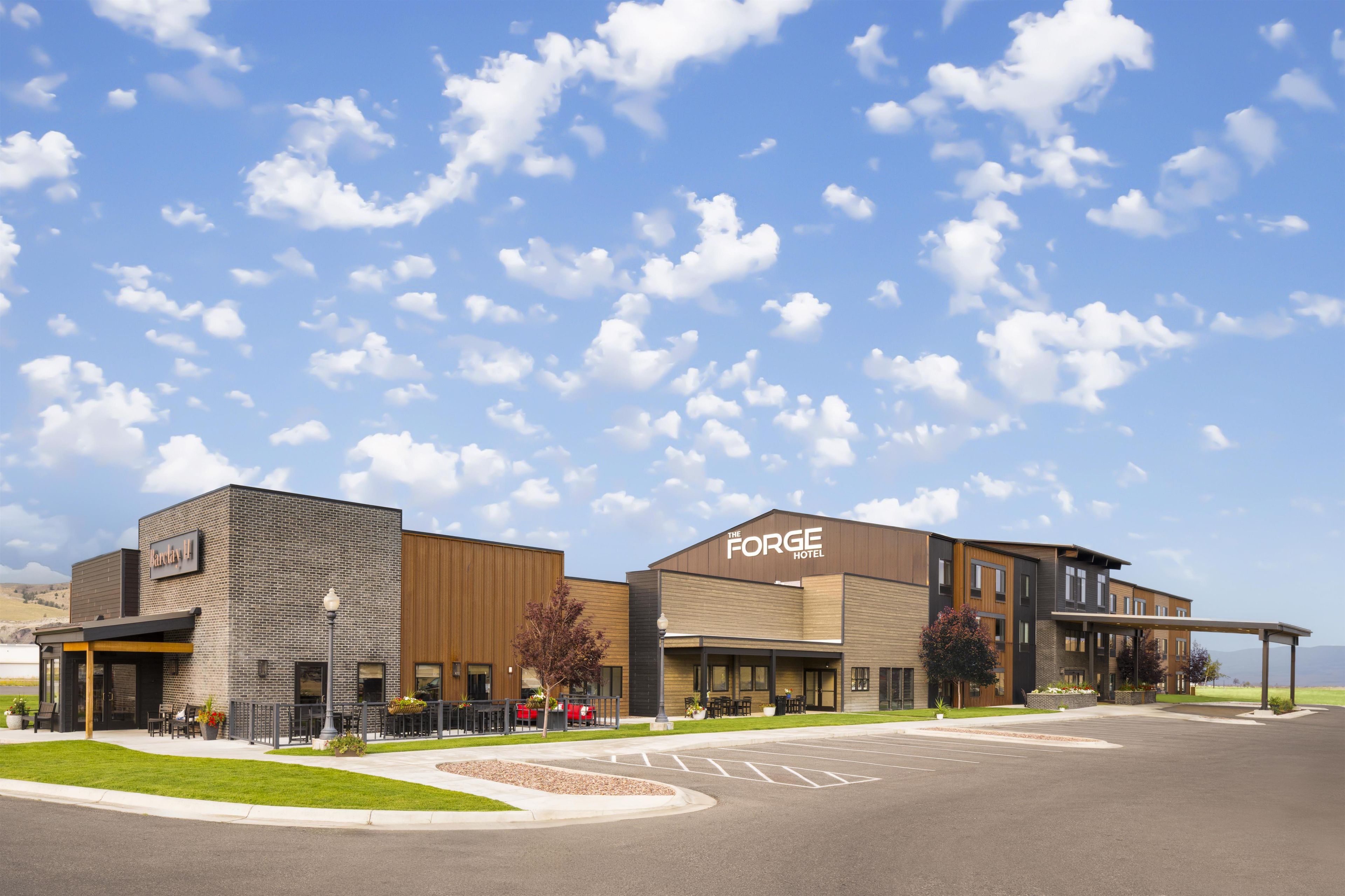 A hotel with a modern design, featuring a brick facade and a large sign for 'The Forge Hotel'.