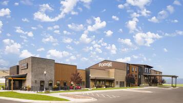 A hotel with a modern design, featuring a brick facade and a large sign for 'The Forge Hotel'.
