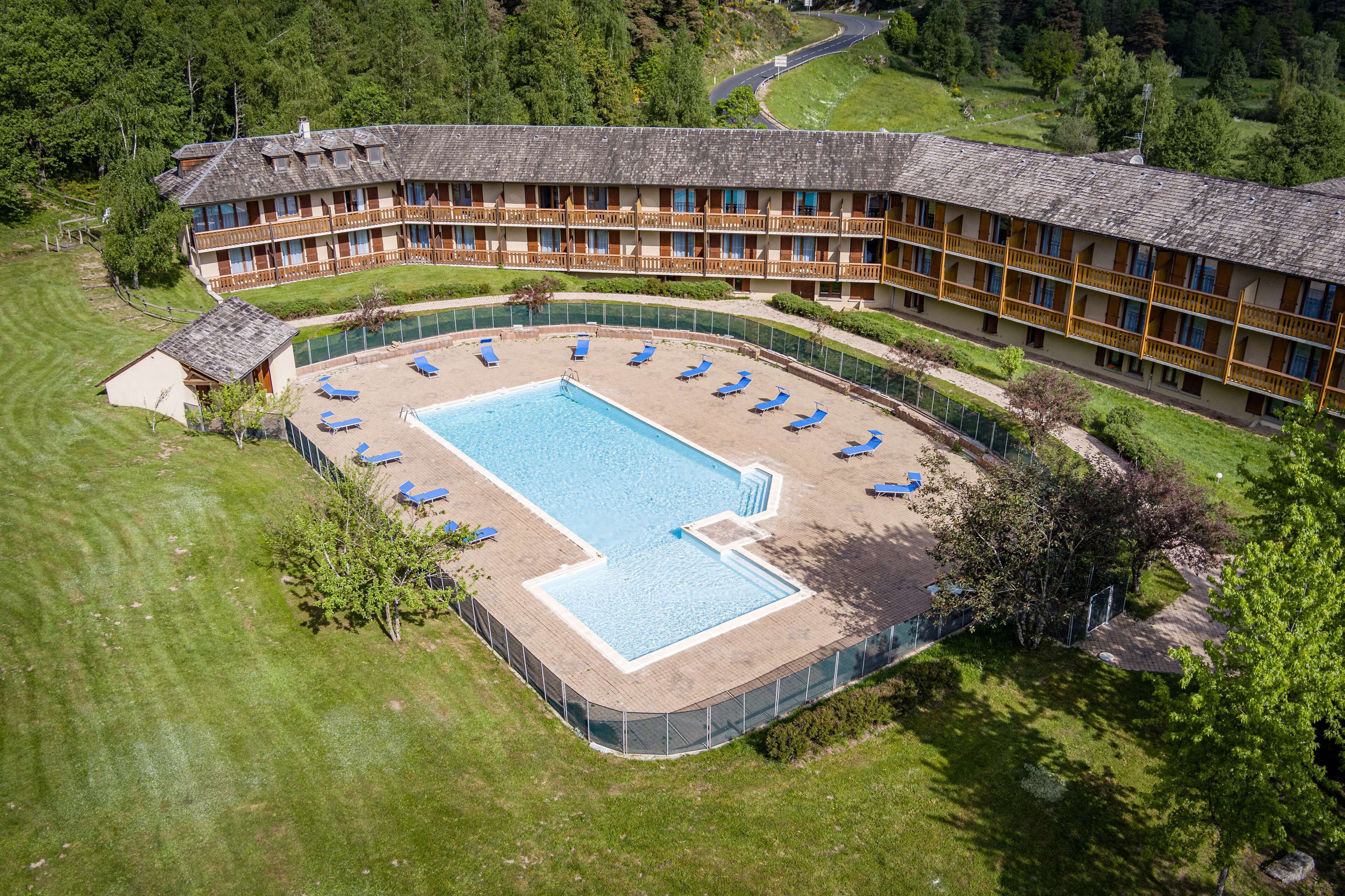 Un grande hotel con piscina circondata da sdraio.