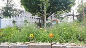 A garden with a variety of flowers and a stone wall. - Frisch Renoviertes, Lichtdurchflutetes Apartment! (Runkel)