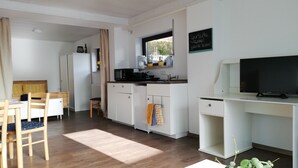 A compact living space with a kitchenette, a dining area, and a TV. - Frisch Renoviertes, Lichtdurchflutetes Apartment! (Runkel)
