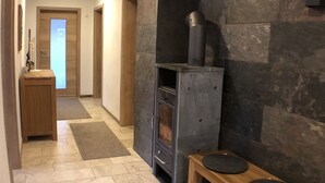 A modern kitchen with a built-in oven, a stone wall, and a wooden bench.