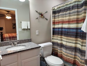 Une salle de bain avec deux lavabos, des toilettes et un rideau de douche.