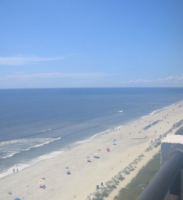 Rannalla, aurinkotuoleja, rantapyyhkeitä