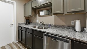 A kitchen with granite countertops, stainless steel appliances, and dark cabinetry. - Serenity Now (Branson)
