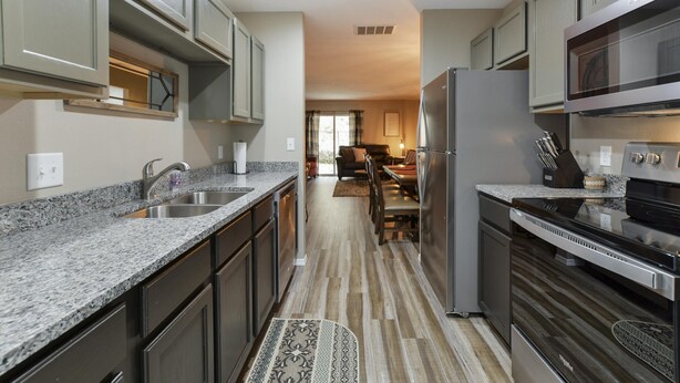 A modern kitchen with granite countertops, stainless steel appliances, and dark cabinetry. - Serenity Now (Branson)