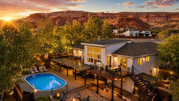 Una casa moderna con piscina, terraza y vistas a la montaña.