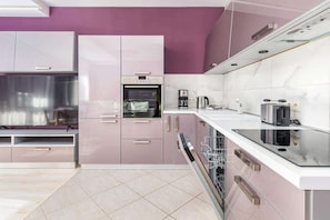 A modern kitchen with a built-in oven, a coffee maker, and a dishwasher.