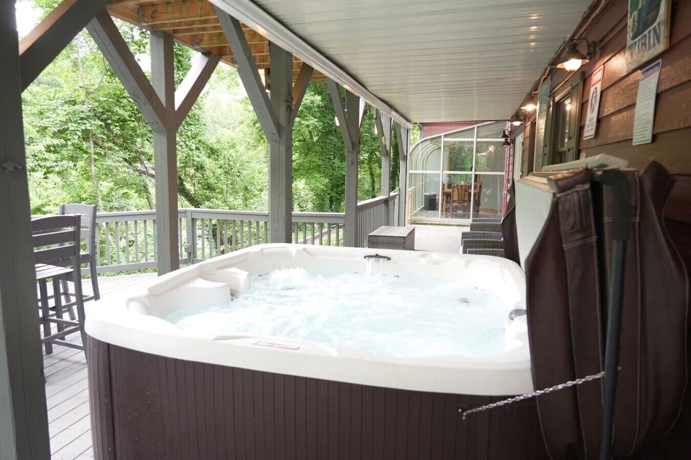 A hot tub on a wooden deck with a view of trees.