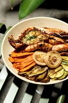Un plato de mariscos y vegetales cocidos.