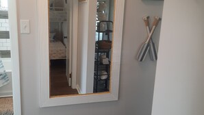 Um corredor com um espelho grande, uma decoração de peixe e um quadro na parede.