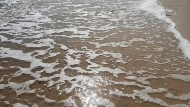 Uma praia com ondas batendo na costa.