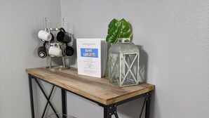 Une table en bois, avec une pancarte, une lanterne et une plante.