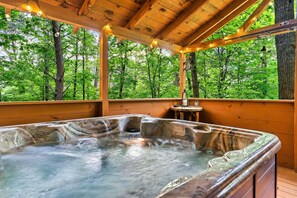 A hot tub in a wooden cabin with a forest view. - Summer Specials! Cozy Cabin, ADA, HotTub, Easy Drive, 3Bdm+Nook, Family Retreat (Sevierville)