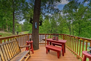 A wooden deck with benches and tables, surrounded by trees and a view of a forested area. - Summer Specials! Cozy Cabin, ADA, HotTub, Easy Drive, 3Bdm+Nook, Family Retreat (Sevierville)