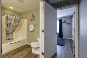 A bathroom with a patterned shower curtain, a toilet, and a towel rack. - Windy City Klassics (Branson)
