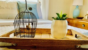 A wooden tray with a birdcage and a vase on a textured white surface. - Cozy, Country Cottage close to Oaklawn, near Bypass (Hot Springs)