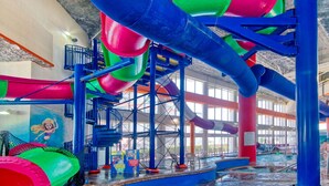 Parco acquatico al chiuso con diverse scivoli e area piscine.