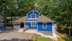 Ein blaues Haus mit Veranda, Treppe und einer kleinen Terrasse.