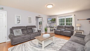 Ein Wohnzimmer mit zwei grauen Sofas, einem Holztisch und einem grauen Teppich.