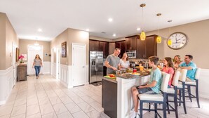A modern kitchen with a central island, stainless steel appliances, and pendant lighting. - Exceptional Villa: Saltwater Pool, No Rear Neighbors, Game Room & Movie Theater (Davenport)
