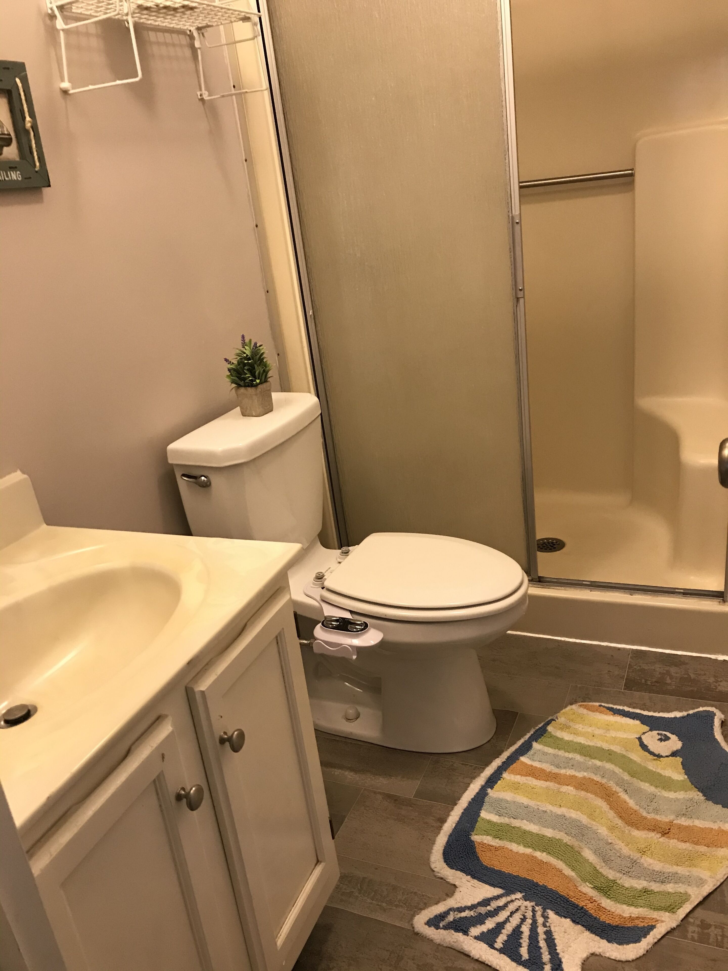 A bathroom with a toilet, sink, and shower.