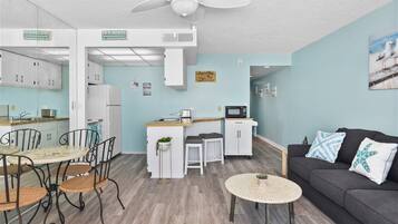 A compact living space with a kitchenette, dining area, and seating area.