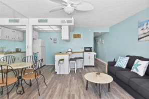 A compact living space with a kitchenette, dining area, and seating area.