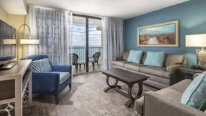 A hotel room with a balcony, a sofa, a dining table, and a painting on the wall. - June 15-22!  Price reduced! 1 bedroom, Peaceful Beachfront, Westwinds (North Myrtle Beach)
