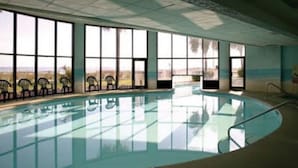 An indoor swimming pool with large windows, chairs along the poolside, and a view of the outdoors. - June 15-22!  Price reduced! 1 bedroom, Peaceful Beachfront, Westwinds (North Myrtle Beach)